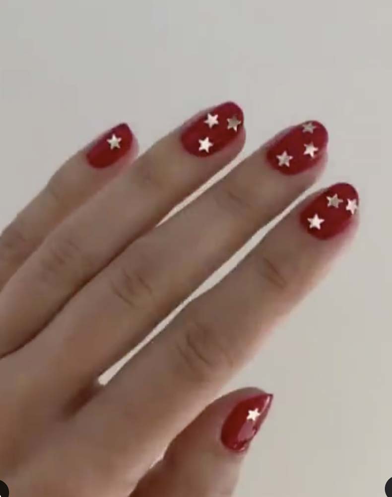 Manicure rossa con stelle oro