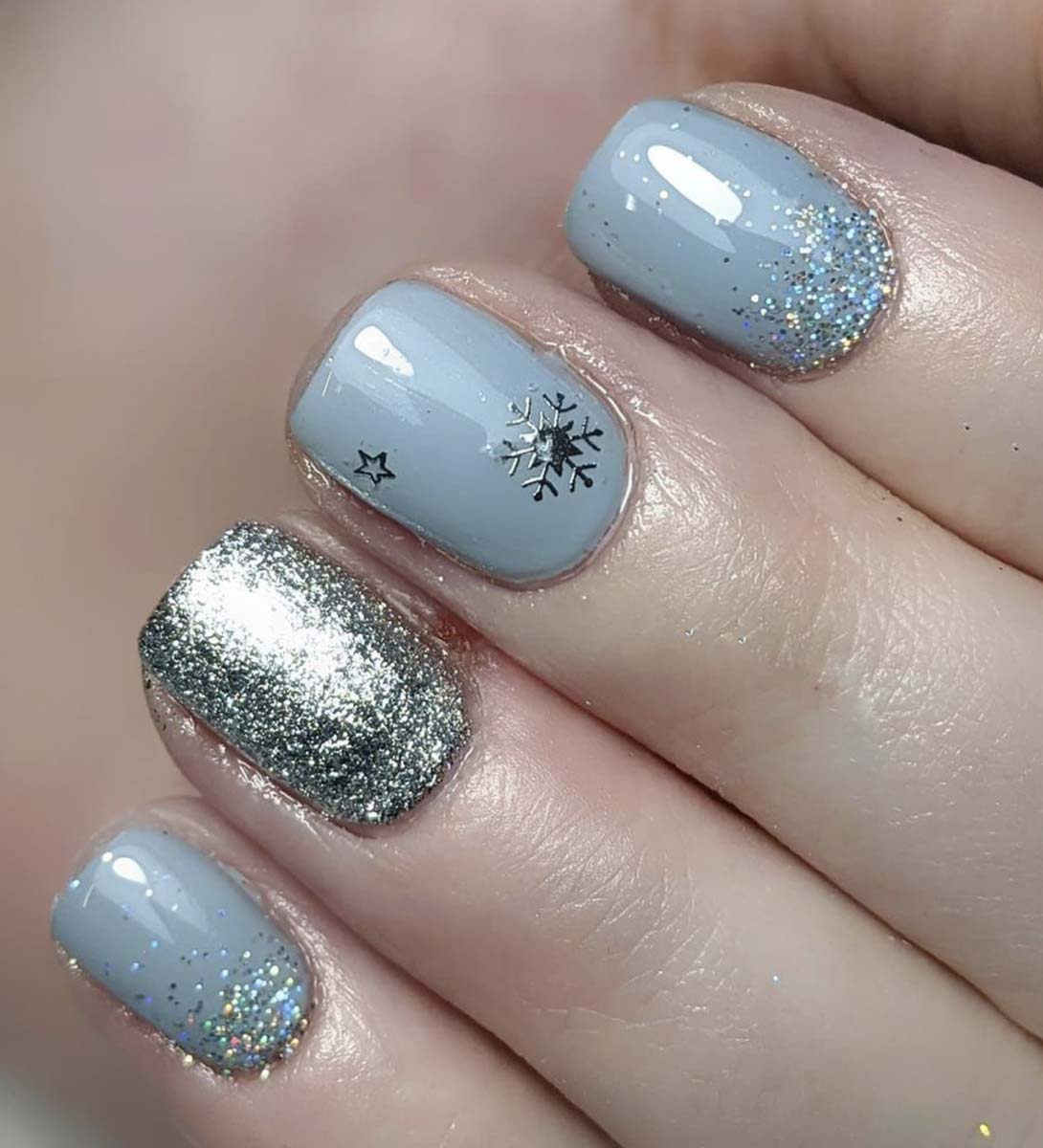 unghie natalizie azzurro ghiaccio, glitter e fiocchi di neve.