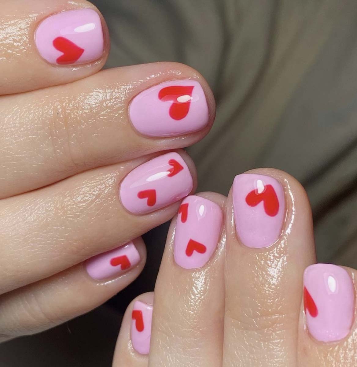 Nail art molto semplice con cuori su base rosa