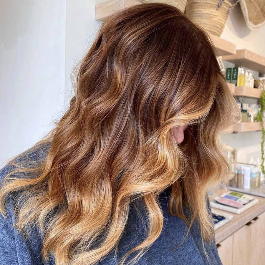 Capelli castani con riflessi fragola e balayage